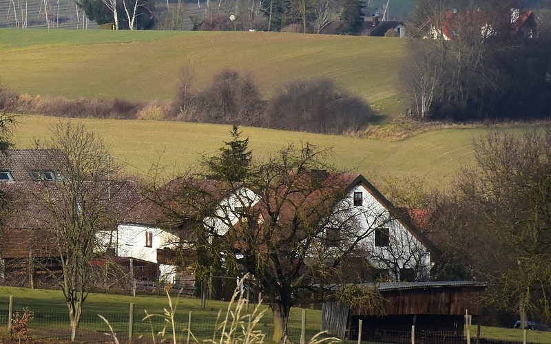 a country farm with many buildings, rolling pastures and gardens